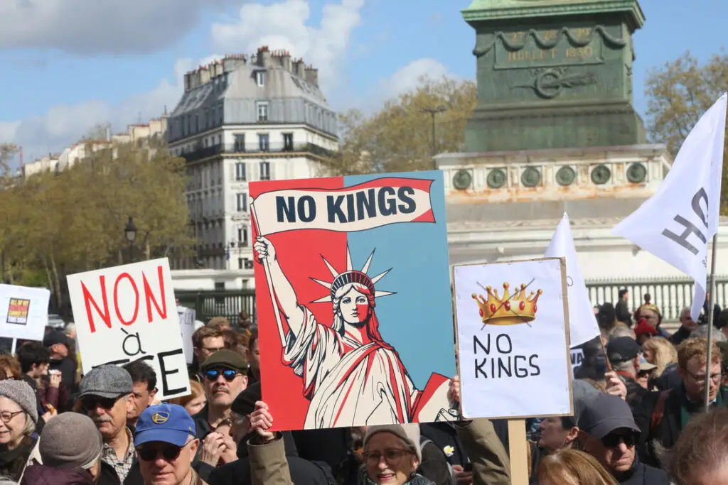 photo shows protestors with signs saying no kings at the third no kings rally in paris france at place de la bastille